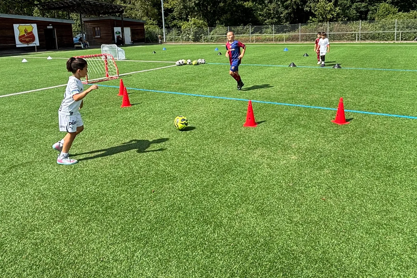 Kind dribbelt beim Training der MK Fußballschule durch einen Hütchenparcours